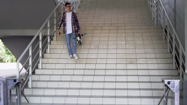 Giù per le scale è un uomo con uno scooter elettrico piegato. Stile di vita tecnologico ecologico. Mobilità elettronica. Trasporto urbano ecologico. — Video Stock