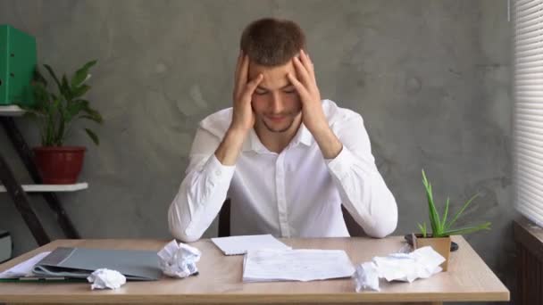 Portrait of an unmotivated businessman with a headache sitting in a company office. Solving financial problems. Creative crisis and depression. Employee burnout without inspiration. — Wideo stockowe