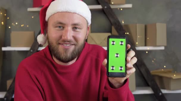 Schöner bärtiger Mann lächelt und zeigt Handy mit grünem Bildschirm. — Stockvideo