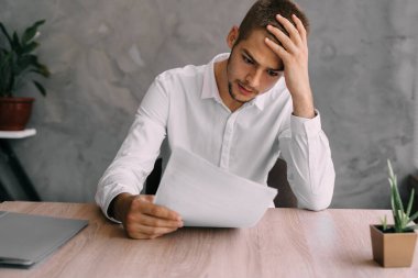 Hasta baş ağrısı olan işçi ya da işadamı sözleşmeyi ya da iflas belgelerini okur. Yönetici danışmanı iş yerinde işe alıyor. Ofis çalışanlarının stresi ve depresyonu. İş ve iş kavramı. Boşluğu kopyala