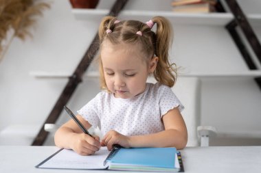 İlkokul öğrencisi anaokulu öğrencisi evde çalışıyor ev ödevlerini el yazısıyla bir deftere yazıyor ya da bir masada oturuyor. Anaokulu öğrencisi internetten öğreniyor. Uzaklık eğitimi kavramı
