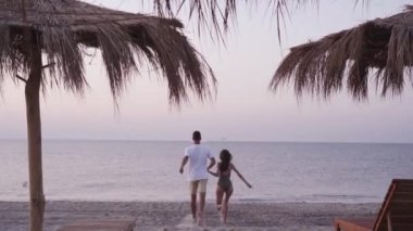 Tropikal ülkelerde balayı, genç bir çift plaja koşar ve orada daireler çizer..