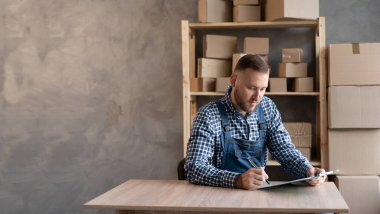 Çevrimiçi Satış Sevkiyatı, Küçük İşletme Sahibi Teslimat Servisi. İşyeri sahibi, postaneye göndermeden önce beyaz işçi tulumu giymiş, kontrol emri almış..