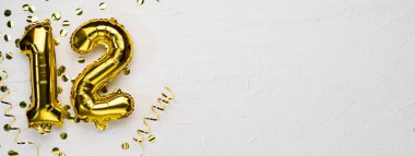 12 numaralı altın folyo balonu. 12 yazılı doğum günü ya da yıldönümü kartı. Gri beton arka plan. Yıldönümü kutlaması. Pankart. Boşluğu kopyala