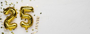 Altın folyo balonu 25 numara. 25 yazılı doğum günü ya da yıldönümü kartı. Gri beton arka plan. Yıldönümü kutlaması. Pankart. Boşluğu kopyala