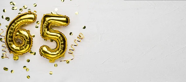 Globo dorado número sesenta y cinco. Tarjeta de cumpleaños o aniversario con la inscripción 65. fondo de hormigón gris. — Foto de Stock