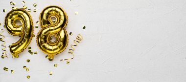 98 numaralı altın folyo balonu. Doğum günü ya da yıldönümü kartında 98 yazılıydı. Gri beton arka plan. Yıldönümü kutlaması. Pankart. Boşluğu kopyala