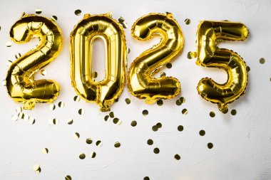 2025 numaralı altın folyo balonu. Yeni yıl 225. ve altın sayılar. Gri beton arka planda 20 ve 25. Rakamlarla dolu şenlikli bir arka planda konfeti. Boşluğu kopyala