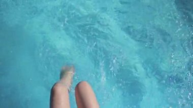 Kadınların ayakları havuza sıçrar ve bol bol deniz spreyi sıkarlar. Yaz tatili.