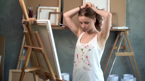 Atelier d'art artiste féminine au repos. Silhouette d'une fille talentueuse près de la photo. Un passe-temps créatif. le peintre prend un pinceau. Concept de créativité d'atelier. Portrait du créateur — Video