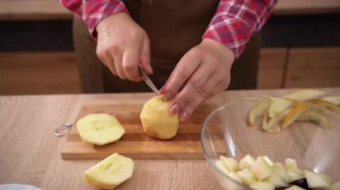 Kadın şef mutfakta tahta tahtada elma kesiyor. Vejetaryen diyet konsepti