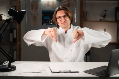 Beyaz önlüklü ciddi bir doktor klinikte gece vardiyasında çalıştığını gösteriyor. Kötü eleştiri ya da tedavi sorunları. Boşluğu kopyala