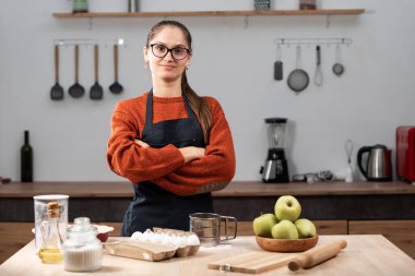 Ev hanımı fırıncı kadının portresi ev mutfağında çalışırken çapraz kollarını tutarak kameraya bakıyor. Meslek kavramı