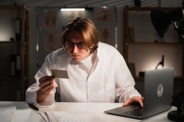 Doktor elinde bir kredi kartı tutuyor. Finansal işlemler ya da sigorta ödemeleri yapıyor. Tıbbi servis kavramları. Boşluğu kopyala