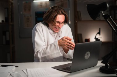 Şüpheci ve şüpheli duygu büken parmakları hastanede gece vardiyasında çalışan erkek doktor. İğneleyici tıbbi işçinin portresi. Boşluğu kopyala