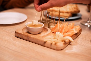 Aperatifler. Bala batırılmış bir dilim çedar peyniri. Peynir tabağı. yakın plan
