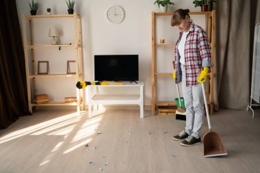 Kadın hademe oturma odasında yerleri süpürüyor. Boşluğu kopyala