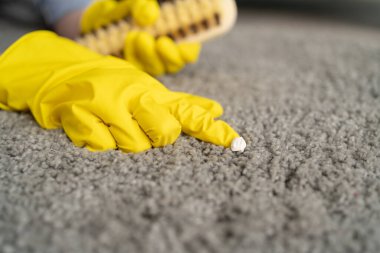 Kadın oturma odasında halıyı kaldırıyor, yakın plan.