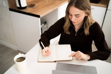 Uzaktan öğrenme konsepti. Evde dizüstü bilgisayar kullanarak online eğitim webinarında yeni bilgiler üzerinde çalışan bir kadın öğrenci. Boşluğu kopyala