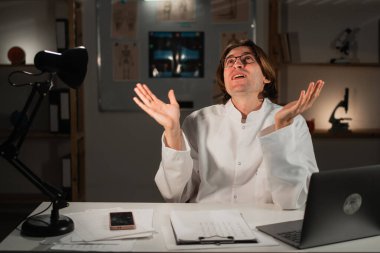 Öfkeli pratisyen doktor gece vardiyasında çalışıyor ve elleri hastane ofisinde her zaman hareket ediyor. Boşluğu kopyala