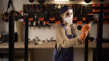 Boyacı, atölyedeki metal yapıları boyamak için siyah boya ve boya fırçası kullanıyor. Boşluğu kopyala