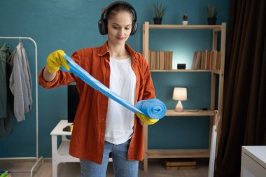 Evini temizleyen mavi çöp torbalı bir kadın. Boşluğu kopyala