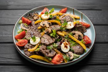 Zarif bir restoran tabağı taze, besleyici salatalar lezzetli et, renkli biberler ve zengin protein bıldırcın yumurtaları ile cömertçe kaplanmış..