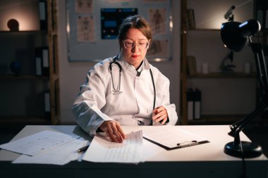 Klinikte gece vardiyasında çalışan doktor kadın. Boşluğu kopyala