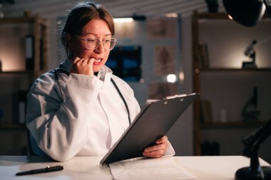 Sinirli kadın doktor, klinikte ya da hastanede gece vardiyasında çalışan stres tırnağını yiyor. Boşluğu kopyala