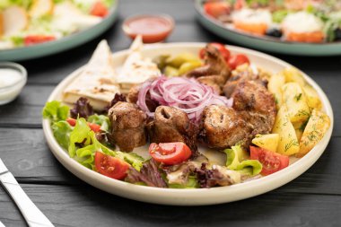 Fırında patates, lavaş, sulguni peyniri ve soğan turşusuyla servis edilen ızgara tavuk şiş parçaları. Kavramsal restoran ızgara menüsü, Kafkas mutfağı ve sıcak yemek.