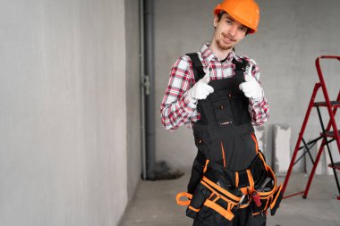İnşaatçı, ustabaşı, alet kemeri takan tamirci kameraya gülümseyen ve inşaat alanında kamerayı sana çeviren işçi. Boşluğu kopyala
