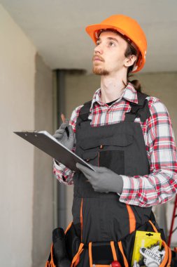 Meslek, inşaat ve inşaat kavramı. Genç bir erkek işçi ya da panosu olan bir müteahhit. Boşluğu kopyala