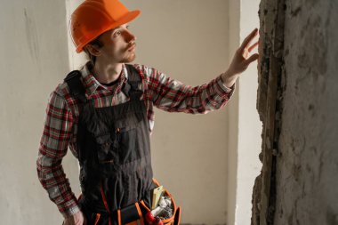 İnşaat işçisi inşaat alanında inceleme yapıyor. İşçi ve iskan binası. Boşluğu kopyala