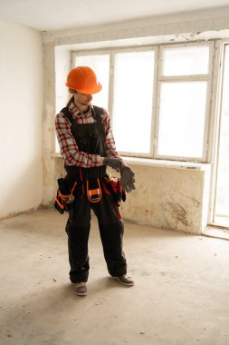 Tamir edilmemiş eski odada alet kemeri olan profesyonel bir müteahhit. Boşluğu kopyala