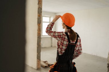 İnşaat alanında geriye doğru duran miğferli tamirci ya da tamirci. Boşluğu kopyala