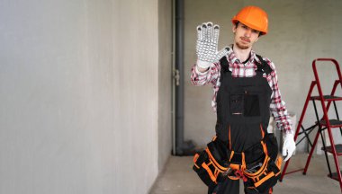 Erkek işçi, inşaatçı ya da tamirci inşaat alanında dur işareti ile reddetme jestini göstermeye hazır. Pankart. Boşluğu kopyala