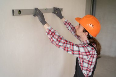 İnşaat işçisi apartman dairesini balon seviyesinde onarıyor. Ev yenileme konsepti