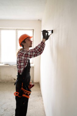 İnşaat işçisi apartman dairesini balon seviyesinde onarıyor. Ev yenileme konsepti