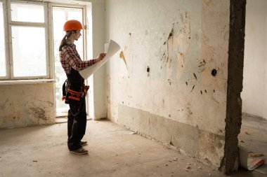Bina planı, tadilat için apartmanda kitap okuyan bir müteahhit. Kat planı, mimar belge hazırlama projesi. Boşluğu kopyala