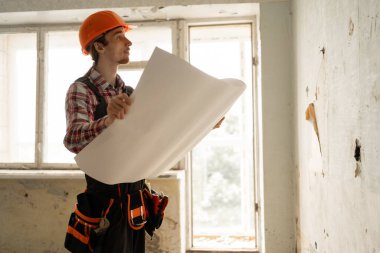 Bina planı, tadilat için apartmanda kitap okuyan bir müteahhit. Kat planı, mimar belge hazırlama projesi. Boşluğu kopyala