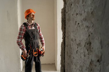 İnşaat alanında üniformalı bir ustabaşı. Kasketli yenileme dairesinde inşaat işçisi. Boşluğu kopyala