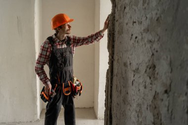 İnşaat alanında alet kemeri ve siper teftişi olan bir müteahhit. İşçi ve iskan binası. Boşluğu kopyala