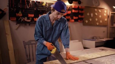 Çalışkan bir atölye çalışanı, gece geç saatlerde marangozluk atölyesinde kendini işine adamış ve gece çalışmalarını ön plana çıkaran bir tahta parçasını kesmeye odaklanır.