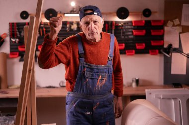 Olgun, agresif bir marangoz, kameraya karşı olumsuz duygular besliyor, mobilyaların yenilenmesi üzerinde çalışıyor. El yapımı, küçük işletme, DIY ve girişimcilik konsepti.