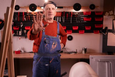 Olgun bir marangoz, atölyedeki mobilya yenileme teklifini reddediyor. El yapımı, küçük işletme, DIY ve girişimcilik konsepti.