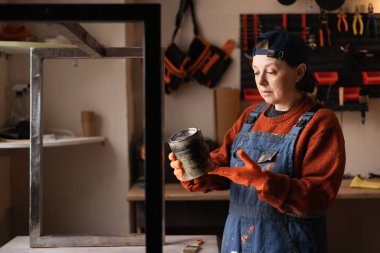 Yenileme, boyama ve geliştirme kavramı. Kendine güvenen kadın zanaatkar portresi boya malzemelerini tutuyor çalışma alanını iç yenileme ve tasarım için hazırlıyor.