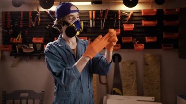 Sıkı çalışma, yorgunluk, meşguliyet kavramı. Tamirci koruyucu eldivenleri çıkartıyor. Yorgun elleri gösteriyor. Endüstriyel garajda gündüz vardiyası bitiyor..