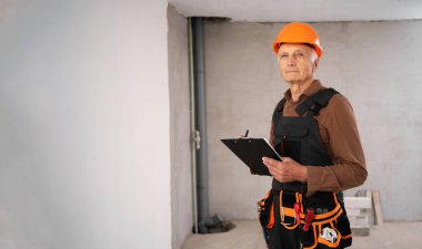 Tadilat odasında panosu olan yaşlı bir inşaat işçisi ya da inşaatçı. meslek, inşaat ve onarım konsepti. Pankart. Boşluğu kopyala