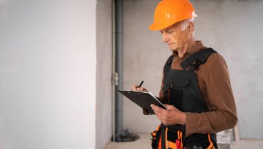 Odasında panosu olan yaşlı bir inşaatçı ya da mimar. kopyalama alanı. meslek, inşaat ve onarım kavramı.