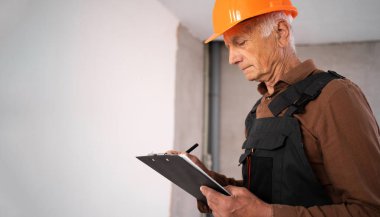 Oda, fotokopi alanı, meslek, inşaat ve onarım konseptinde çalışan yaşlı erkek inşaatçı veya mimar.